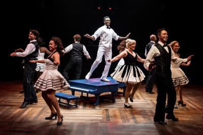 Tyler Johnson-Campion and Kelly Felthous (center) surrounded by ensemble in 'White Christmas' at Marriott Theatre
